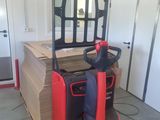 a red forklift truck parked in a garage