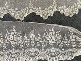 two pieces of white lace on a black surface