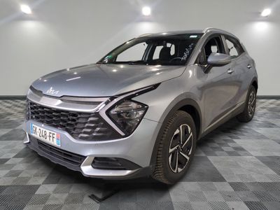 La voiture argentée est garée dans le showroom, sur le sol à damier.