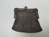 an old silver metal purse with a chain around it