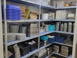 many plates and pans on the shelves in the kitchen
