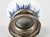 a silver vase with a blue and white design on it