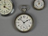 three different types of clocks displayed on a table