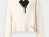 un pull blanc sur lequel est dessiné un cœur noir