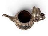 a silver teapot with a handle on a white background