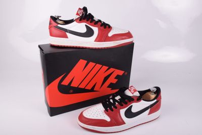 une paire de baskets rouges et blanches posée sur une boîte