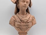 an image of a clay bust of a woman with a hat on