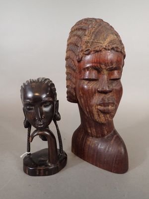 wooden head of a woman and a small statue of a man