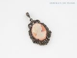 a close up of a pendant with a woman ' s face on it