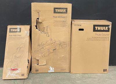 three boxes of thule tools sitting on a floor next to a wall