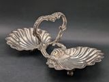a pair of silver plated dishes on a black surface