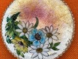 an image of a picture of a brooch with flowers painted on it