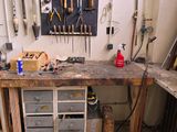 a workbench with many tools on it in a room