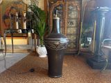 a large black vase sitting on the floor in a living room