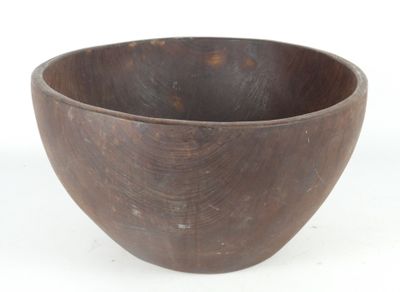 a wooden bowl that is sitting on a white surface
