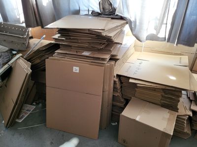 une pile de cartons posée par terre près d'une fenêtre