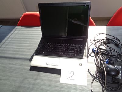 a laptop computer sitting on top of a wooden table