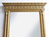 an image of a gold framed mirror against a white wall
