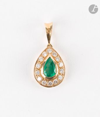 un gros plan d'un pendentif en or orné d'une pierre verte en forme de larme