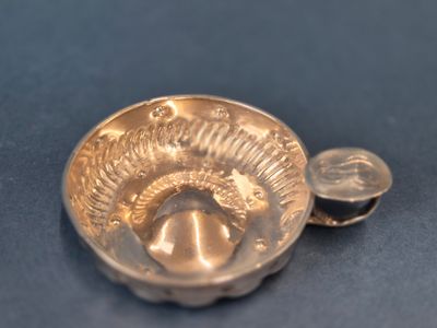 un petit bol contenant une pièce de monnaie, posé sur une table