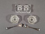 three pieces of glass with spoons and spoon rest on a table
