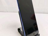 the back of a cell phone on a stand on a white surface