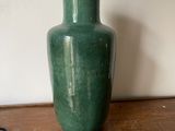 un vase vert posé sur une table en bois