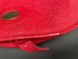 a close up of a red purse on a black surface
