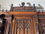 a large wooden cabinet with carvings on the top of it