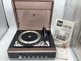 un tourne-disque posé sur une table, à côté d'un livre
