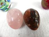 three different colored stones sitting on a white surface