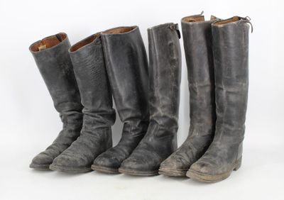 quatre paires de bottes sont alignées sur une surface blanche