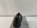 men ' s black leather shoes in a box on a white surface