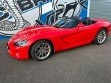 a picture of a red sports car parked in front of a building