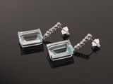 pair of aquamarinee and white topaze earrings on a black surface