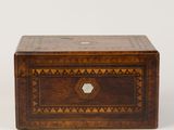 une petite boîte en bois ornée d'un motif géométrique sur le devant