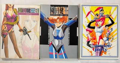 Trois livres sur les anime sont alignés sur une surface blanche