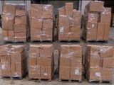 de nombreux cartons empilés sur des palettes dans un entrepôt