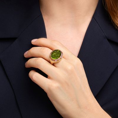 La femme porte une bague sertie d'une pierre verte.