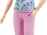 poupée Barbie aux cheveux blonds, vêtue d'un pantalon rose et tenant un stéthoscope