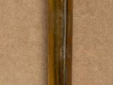 a small brass object on a table with a brown background