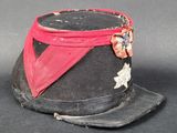 un chapeau noir orné d'un ruban rouge et d'une étoile