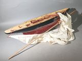 une petite maquette de bateau posée sur un tissu blanc