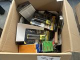 une boîte en carton remplie de piles et des piles par terre