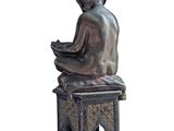 statue of a woman sitting on a stool with a bowl in her hands