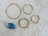three rings and a ring with a blue topaz stone on a table