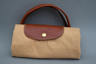 sac en toile beige et marron avec une poignée en cuir