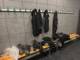 several pairs of shoes are lined up on a bench in a locker