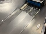 a metal conveyor belt with a blue brush on it