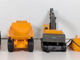 three toy construction vehicles that are sitting on a table